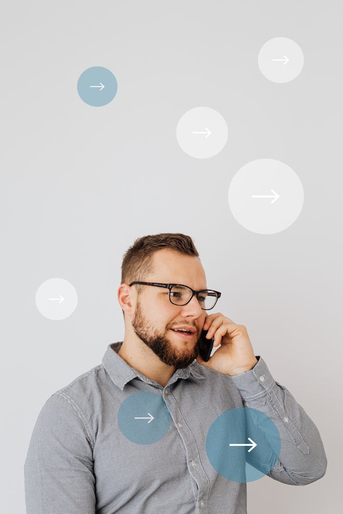 gallery-5 Young man standing indoors engaged in a phone call, surrounded by digital arrow overlays.